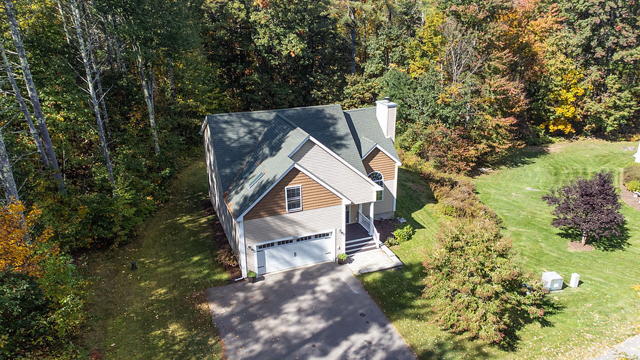 Aerial view of the home surrounded by woods
