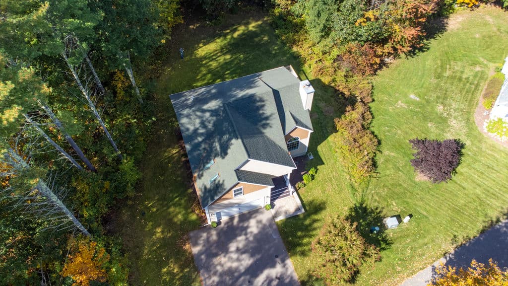 Aerial view straight down over the home, the yard, and the woods